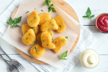 Tavuk nuggets ve beyaz ahşap zemin, kopya alanı üzerine sos. Fried nuggets ketçap ve mayonez ile.