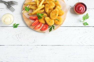 Tavuk nuggets, kızarmış patates ve beyaz ahşap zemin, üzerine sosu alanı kopyalayın. Fried nuggets ve ketçap ve mayonez ile patates.
