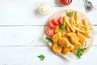 Tavuk nuggets, kızarmış patates ve beyaz ahşap zemin, üzerine sosu alanı kopyalayın. Fried nuggets ve ketçap ve mayonez ile patates.