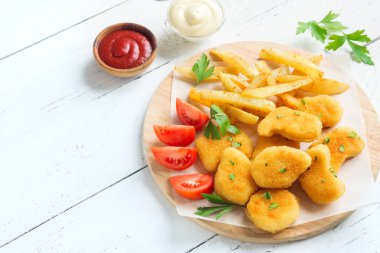 Tavuk nuggets, kızarmış patates ve beyaz ahşap zemin, üzerine sosu alanı kopyalayın. Fried nuggets ve ketçap ve mayonez ile patates.