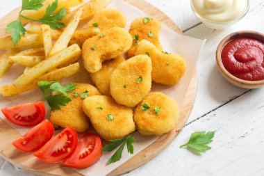 Tavuk nuggets, kızarmış patates ve beyaz ahşap zemin, üzerine sosu alanı kopyalayın. Fried nuggets ve ketçap ve mayonez ile patates.