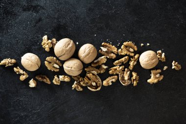 Organik ceviz. Üstten görünüm, siyah taş zemin üzerine ceviz alanı Kopyala.