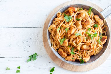Domates soslu tavuk, maydanoz tavada spagetti makarna. Tavuk spagetti makarna kopya alanı, Italyan Mutfagi ile beyaz ahşap zemin üzerinde.