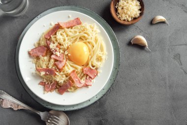 Spagetti carbonara Makarna yumurta sosu, pastırma ve rendelenmiş parmesan peynir - gri beton zemin üzerine ev yapımı sağlıklı İtalyan Makarna