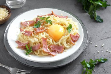 Spagetti carbonara Makarna yumurta sosu, pastırma ve rendelenmiş parmesan peynir - gri beton zemin üzerine ev yapımı sağlıklı İtalyan Makarna