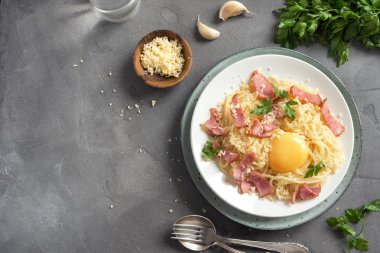 Spagetti carbonara Makarna yumurta sosu, pastırma ve rendelenmiş parmesan peynir - gri beton zemin üzerine ev yapımı sağlıklı İtalyan Makarna