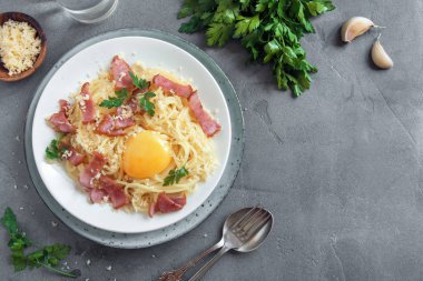 Spagetti carbonara Makarna yumurta sosu, pastırma ve rendelenmiş parmesan peynir - gri beton zemin üzerine ev yapımı sağlıklı İtalyan Makarna