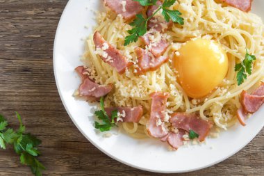 Spagetti carbonara Makarna yumurta sosu, pastırma ve rendelenmiş parmesan peynir - ev yapımı sağlıklı İtalyan makarna carbonara ahşap arka plan üzerinde