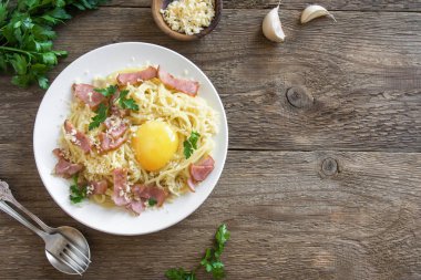 Spagetti carbonara Makarna yumurta sosu, pastırma ve rendelenmiş parmesan peynir - rustik ahşap zemin üzerine ev yapımı sağlıklı İtalyan Makarna