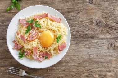 Spagetti carbonara Makarna yumurta sosu, pastırma ve rendelenmiş parmesan peynir - ev yapımı sağlıklı İtalyan makarna carbonara ahşap arka plan üzerinde