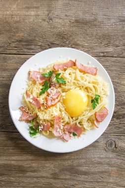 Spagetti carbonara Makarna yumurta sosu, pastırma ve rendelenmiş parmesan peynir - rustik ahşap zemin üzerine ev yapımı sağlıklı İtalyan Makarna