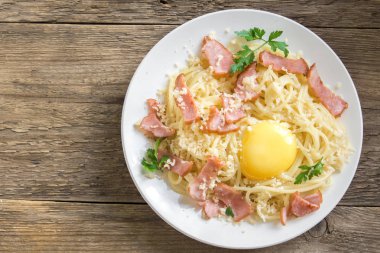 Spagetti carbonara Makarna yumurta sosu, pastırma ve rendelenmiş parmesan peynir - rustik ahşap zemin üzerine ev yapımı sağlıklı İtalyan Makarna