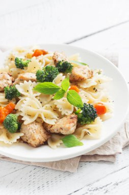 Farfalle makarna Tavuk ve sebze ile. Beyaz ahşap arka planda, kopya alanı makarna salatası.