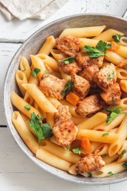 Domates soslu tavuk, maydanoz tavada penne makarna. Tavuk İtalyan penne makarna ile kopya alanı, İtalyan yemeği beyaz arka plan üzerinde.