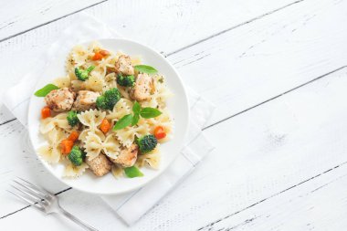 Farfalle makarna Tavuk ve sebze ile. Beyaz ahşap arka planda, kopya alanı makarna salatası.