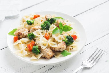 Farfalle makarna Tavuk ve sebze ile. Beyaz ahşap arka planda, kopya alanı makarna salatası.