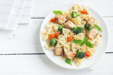 Farfalle makarna Tavuk ve sebze ile. Beyaz ahşap arka planda, kopya alanı makarna salatası.