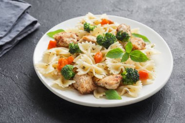 Farfalle makarna Tavuk ve sebze ile. Siyah arka plan, kopya alanı üzerine makarna salatası.