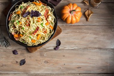 Kabak ve dökme demir tavada pastırma ile sonbahar makarna. Ahşap ev yapımı spagetti kabak makarnaya, kopya alanı. Sonbahar gıda.