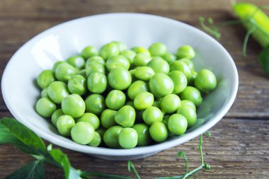 Rustik ahşap arka plan - sağlıklı organik yeşil bahar madde yemek pişirmek için hazır ıslak zeminde organik yeşil bezelye