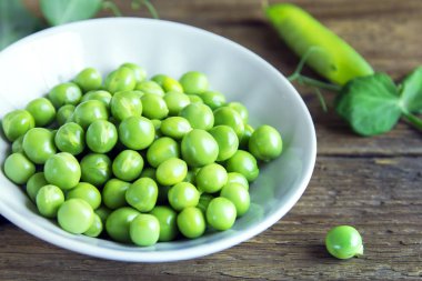 Rustik ahşap arka plan - sağlıklı organik yeşil bahar madde yemek pişirmek için hazır ıslak zeminde organik yeşil bezelye