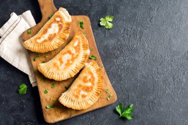 Ev yapımı derin kızarmış sebze samosas (köftesi, burekas) rustik siyah arka planda - vejetaryen kızarmış hamur işleri için meze