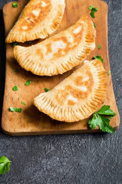 Ev yapımı derin kızarmış sebze samosas (köftesi, burekas) rustik siyah arka planda - vejetaryen kızarmış hamur işleri için meze