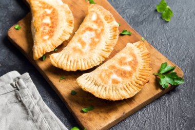 Ev yapımı derin kızarmış sebze samosas (köftesi, burekas) rustik siyah arka planda - vejetaryen kızarmış hamur işleri için meze