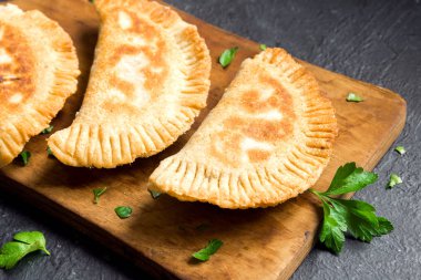 Ev yapımı derin kızarmış sebze samosas (köftesi, burekas) rustik siyah arka planda - vejetaryen kızarmış hamur işleri için meze