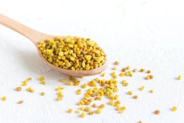 Arı polen içinde kaşık beyaz arka plan üzerinde. Sağlıklı organik ham diyet vejetaryen gıda içerikler - arı polen.