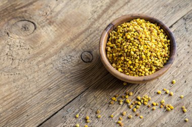 Arı polen kase ahşap arka plan üzerinde. Sağlıklı organik ham diyet vejetaryen gıda içerikler - arı polen.