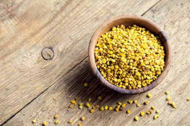 Arı polen kase ahşap arka plan üzerinde. Sağlıklı organik ham diyet vejetaryen gıda içerikler - arı polen.