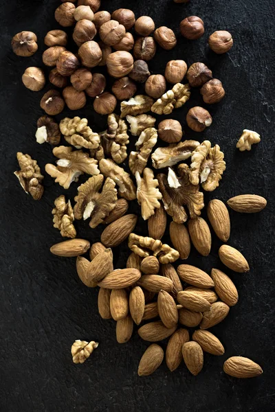 Organic Nuts Various Nuts Walnuts Hazelnuts Almonds Black Stone Background — Stock Photo, Image