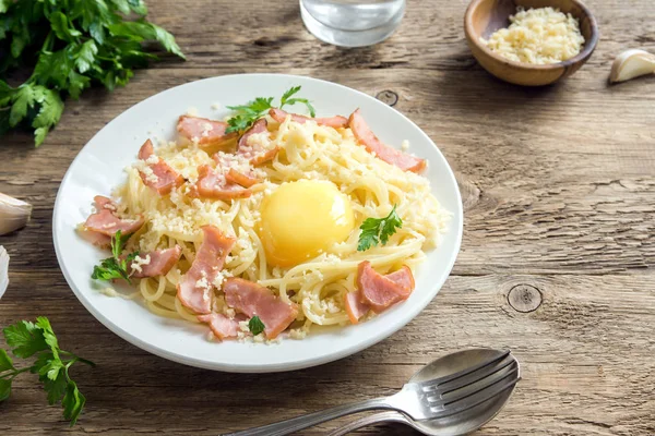 Spagetti carbonara Makarna yumurta sosu, pastırma ve rendelenmiş parmesan peynir - rustik ahşap zemin üzerine ev yapımı sağlıklı İtalyan Makarna