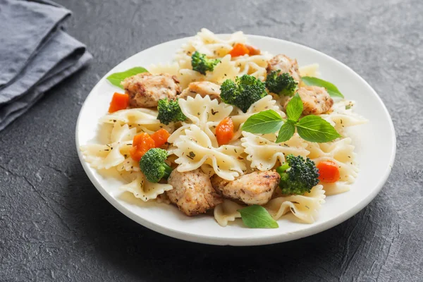 Farfalle makarna Tavuk ve sebze ile. Siyah arka plan, kopya alanı üzerine makarna salatası.