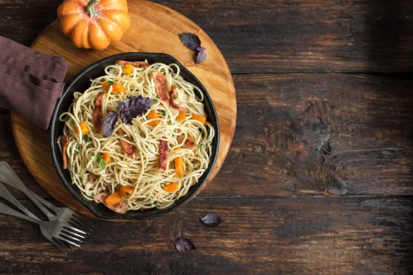 Kabak ve dökme demir tavada pastırma ile sonbahar makarna. Ahşap ev yapımı spagetti kabak makarnaya, kopya alanı. Sonbahar gıda.