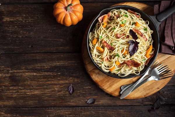 Kabak ve dökme demir tavada pastırma ile sonbahar makarna. Ahşap ev yapımı spagetti kabak makarnaya, kopya alanı. Sonbahar gıda.