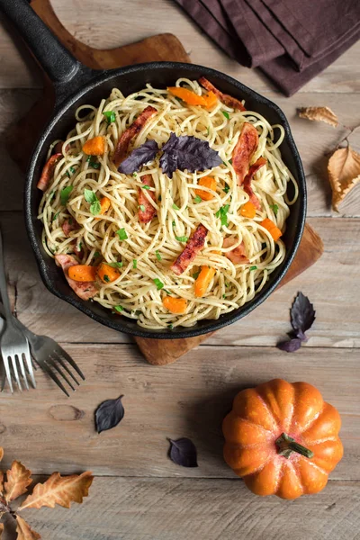 Kabak ve dökme demir tavada pastırma ile sonbahar makarna. Ahşap ev yapımı spagetti kabak makarnaya, kopya alanı. Sonbahar gıda.