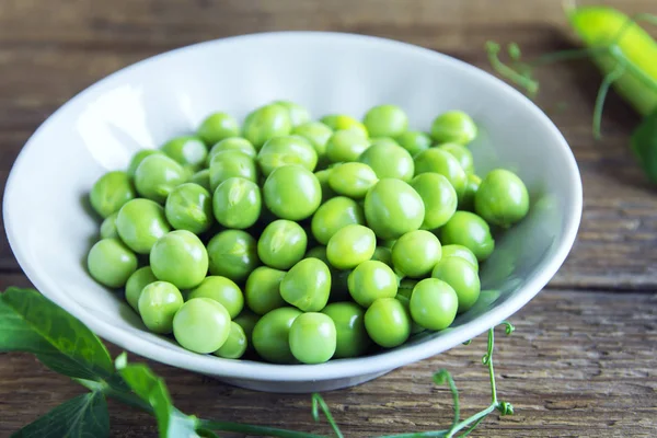 Rustik ahşap arka plan - sağlıklı organik yeşil bahar madde yemek pişirmek için hazır ıslak zeminde organik yeşil bezelye
