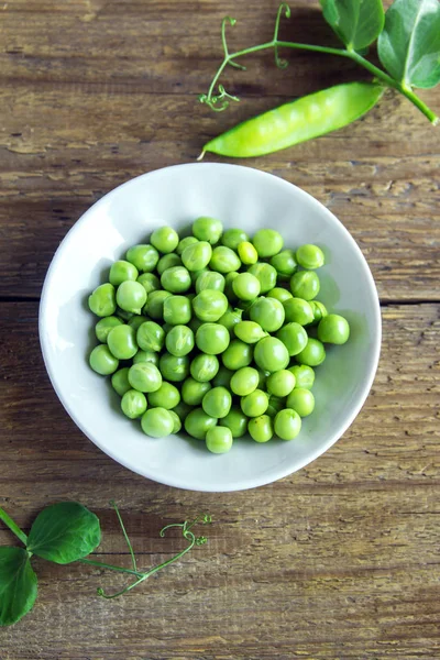 Rustik ahşap arka plan - sağlıklı organik yeşil bahar madde yemek pişirmek için hazır ıslak zeminde organik yeşil bezelye
