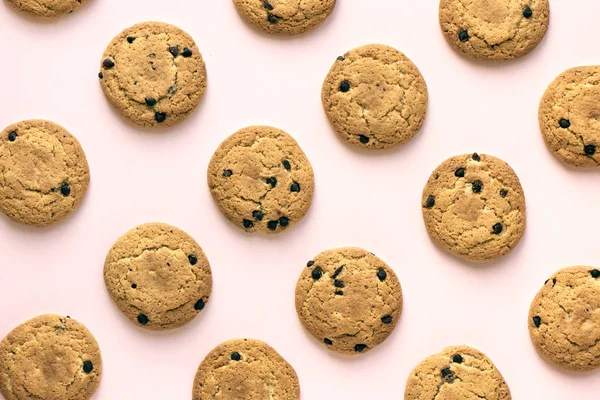 Çikolatalı kurabiye pembe pastel arka planda, üstten görünüm.