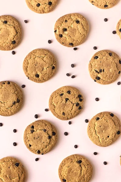 Çikolatalı kurabiye pembe pastel arka planda, üstten görünüm.