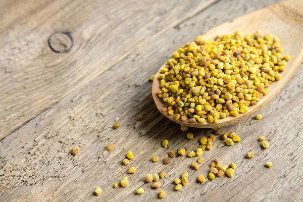 Arı polen içinde kaşık ahşap arka plan üzerinde. Sağlıklı organik ham diyet vejetaryen gıda içerikler - arı polen.