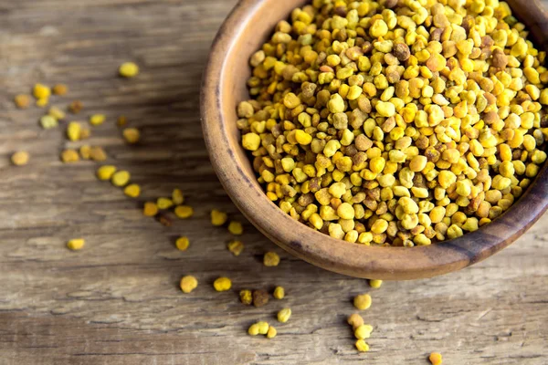 Arı polen kase ahşap arka plan üzerinde. Sağlıklı organik ham diyet vejetaryen gıda içerikler - arı polen.