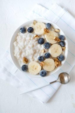 Ceviz, yaban mersini ve muz kase - sağlıklı organik kahvaltı, meyve, bal ve fındık ile yulaf yulaf lapası