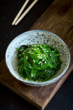 Chuka yosun salata üzerinde siyah arka plan, seramik kase alanı kopyalayın. Japon mutfağı - Chuka salata