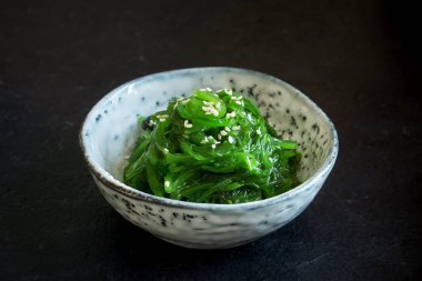 Chuka yosun salata üzerinde siyah arka plan, seramik kase alanı kopyalayın. Japon mutfağı - Chuka salata