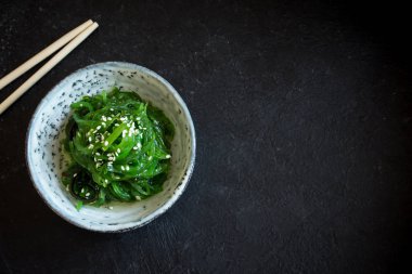 Chuka yosun salata üzerinde siyah arka plan, seramik kase alanı kopyalayın. Japon mutfağı - Chuka salata