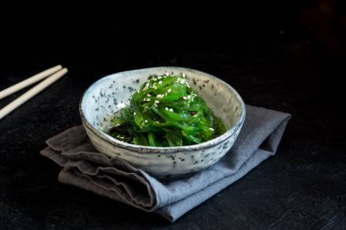 Chuka yosun salata üzerinde siyah arka plan, seramik kase alanı kopyalayın. Japon mutfağı - Chuka salata