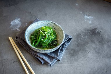 Chuka yosun salata üzerine beton arka plan, seramik kase alanı kopyalayın. Japon mutfağı - Chuka salata